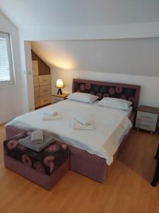 a bedroom with a large bed with two towels on it at Apartmani Milojić in Soko Banja