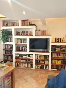 a living room with white book shelves filled with books at Casa di Grazia in Forio d'Ischia