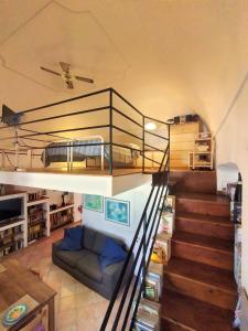 una sala de estar con una escalera con una cama. en Casa di Grazia, en Isquia