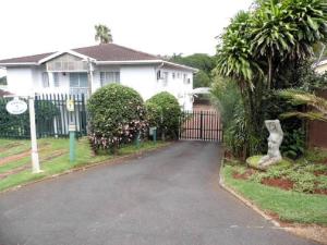 a driveway in front of a house with a gate at Bougainvillea BNB in Durban