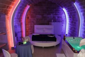 Zimmer mit einem Bett und einer Badewanne in einer Ziegelwand in der Unterkunft Relax Santa Cecilia in Gravina in Puglia