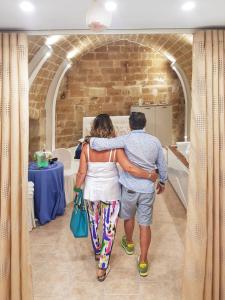 a man and a woman walking through a room at Relax Santa Cecilia in Gravina in Puglia