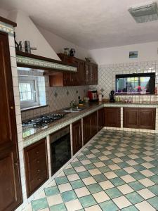 a kitchen with wooden cabinets and a tiled floor at Casa Impagliazzo in Ischia