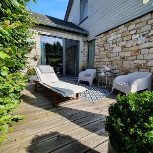 a patio with two chairs and a bench on it at B&B Maison Pierreuse in Sart-lez-Spa