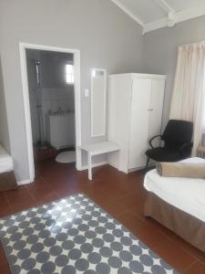 Habitación con cama y baño con espejo. en The Old Mill Hotel, en Machadodorp