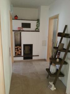 a living room with a fireplace and a ladder at Ferienwohnung und Sommerhaus unter der Burg in Falkenberg