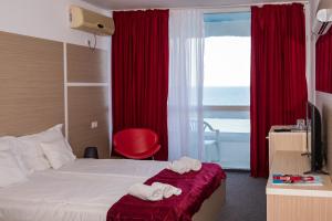a hotel room with a bed and a window at Hotel Opal in Jupiter