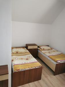 3 camas sentadas en una habitación con una pared en Noclegi Piotrków Tryb, en Piotrków Trybunalski