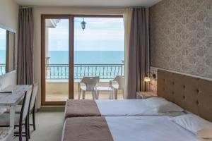 een hotelkamer met een bed en uitzicht op de oceaan bij Paraiso Theopolis - All Inclusive in Obzor