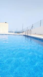 une grande piscine d'eau bleue dans l'établissement Adosado con fantásticas vistas al mar y piscina., à Peñíscola