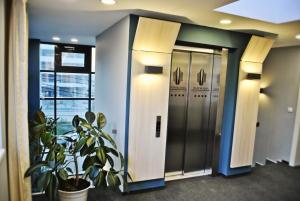 an elevator in an office lobby with a plant at Panorama Business Inn in Cluj-Napoca