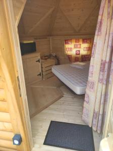 ブルティニョール・シュル・メールにあるCamping Les Gatinellesのログキャビン内のベッド1台が備わる小さな客室です。