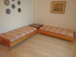 two beds in a room with plates on the wall at Διαμέρισμα δίπλα στη θάλασσα, παραλία Μαρκοπούλου in Oropós +6 photos