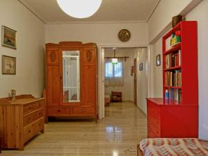 オロポスにあるΔιαμέρισμα δίπλα στη θάλασσα, παραλία Μαρκοπούλουの赤いドレッサーと赤いキャビネット付きのベッドルーム