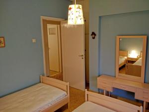 奧羅波斯的住宿－Διαμέρισμα δίπλα στη θάλασσα, παραλία Μαρκοπούλου，一间带镜子和床的小卧室