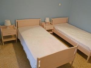 オロポスにあるΔιαμέρισμα δίπλα στη θάλασσα, παραλία Μαρκοπούλουのベッド2台(ナイトスタンド付)が備わる客室です。