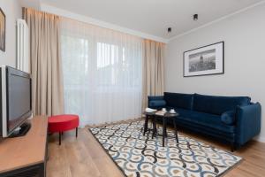 ein Wohnzimmer mit einem blauen Sofa und einem roten Stuhl in der Unterkunft Apartment Warsaw Old Town by Renters in Warschau