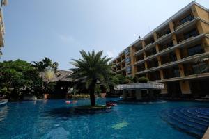 a swimming pool with a palm tree in front of a building at LK Mantra Pura Resort in Pattaya