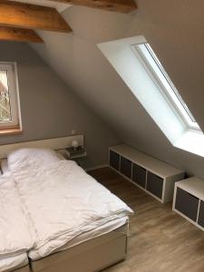 um quarto com uma cama e um telhado inclinado em Ferienwohnung am Storchnest em Kenz
