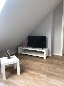 a living room with a flat screen tv on a white entertainment center at Ferienwohnung am Storchnest in Kenz