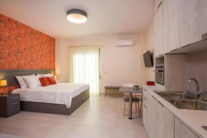 een slaapkamer met een bed en een keuken met een wastafel bij Oleana City Center in Rhodos-stad