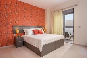 een slaapkamer met een bed en een rode muur bij Oleana City Center in Rhodos-stad
