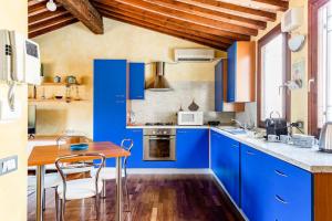 une cuisine avec des placards bleus et une table en bois dans l'établissement Residence dei Frutti pieno centro - Il Cedro, à Padoue