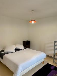 a bedroom with a white bed and a chair at hotel du commerce in Fauville-en-Caux