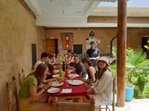 a group of people sitting at a table in a restaurant at ZEN ECOLODGE in Tighli