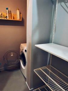 - une buanderie avec un lave-linge et une étagère dans l'établissement Modern city center apartment, à Bénévent