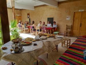 a group of children sitting at a table in a room at ZEN ECOLODGE in Tighli