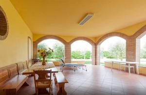 a living room with arched windows and a table and chairs at CASCINA TABACHERA x10 Vineyard House - GARDA LAKE in Pozzolengo