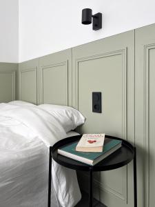 a bedroom with a bed and a table with a book on it at VILLA VLAS - Chambre d'Hôte - Limoges in Limoges