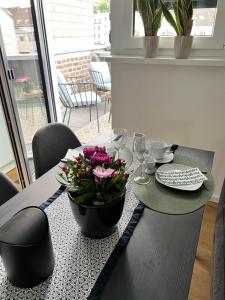 a dining room table with a black table top with flowers on it at BeeHome Euskirchen in Euskirchen