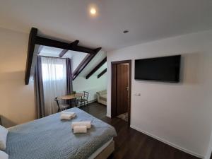 a bedroom with a bed and a flat screen tv at Apartments and Rooms Jerkovic in Korenica