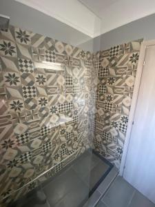 a bathroom with a tiled wall and a shower at Theo Appartement Athen in Athens