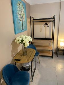 a room with a table and chairs and a vase of flowers at Theo Appartement Athen in Athens
