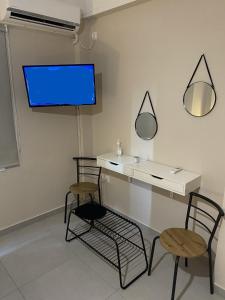 a room with two chairs and a desk and a tv at Theo Appartement Athen in Athens