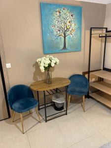 a table with two chairs and a vase with flowers at Theo Appartement Athen in Athens
