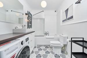 a white bathroom with a washer and dryer at Heart of Wroclaw Uniwersytecka by Renters in Wrocław