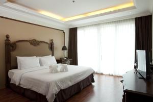 a bedroom with a bed with two stuffed animals on it at LK Miracle Suite - SHA Extra Plus in Pattaya South