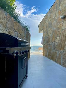 an outdoor kitchen with a stove and a stone wall at Seaside Resort in Trieste