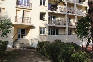 ロアンヌにあるApart'hotel Les Floraliesの階段とバルコニー付きのアパートメントビル