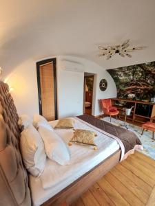 1 dormitorio con 1 cama grande con almohadas en AKIS namelis medyje- Dinosaur Park en Klaipėda