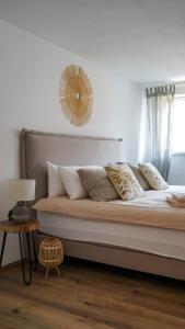 ein Bett mit Kissen und einem Spiegel an der Wand in der Unterkunft CASA CASSAI - Casa Milo in Meiningen