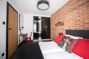 um quarto com uma parede de tijolos e uma cama em Loft em Szczecin
