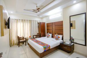 a bedroom with a large bed and a mirror at FabHotel Winter Line Inn in Mussoorie