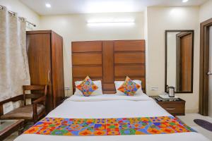 a bedroom with a large bed with a wooden headboard at FabHotel Winter Line Inn in Mussoorie