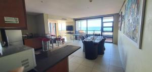 a kitchen with a view of a room with a view of the ocean at Accommodation Front - Tastefully Furnished 6 Sleeper with Ocean Views in Durban