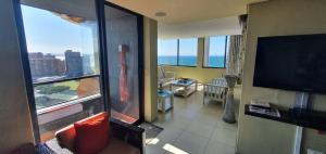 a living room with a large window and a television at Accommodation Front - Tastefully Furnished 6 Sleeper with Ocean Views in Durban